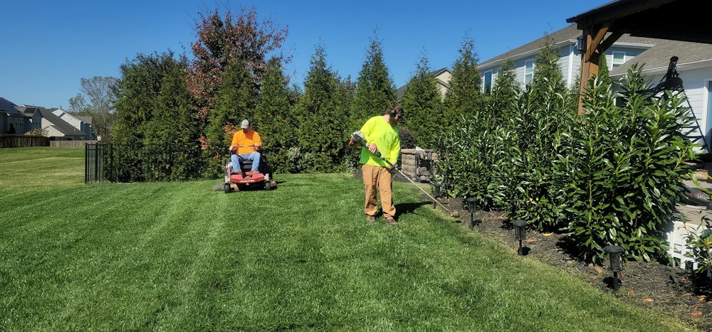 Gardeners mowing and tidying a large garden